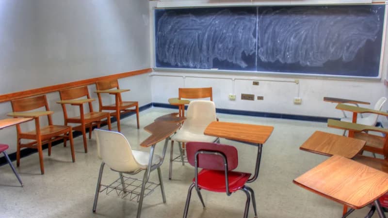 Empty classroom with a large chalkboard covered in chalk marks — learning the French imparfait